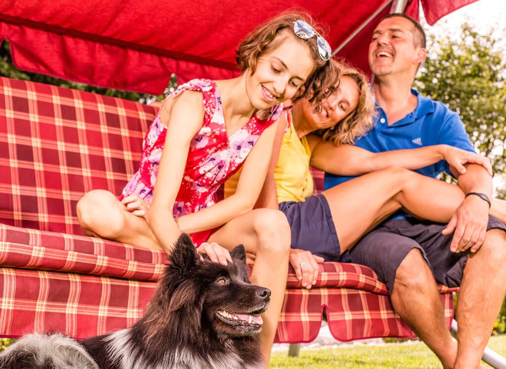 Famiglia che ride sul dondolo con il cane